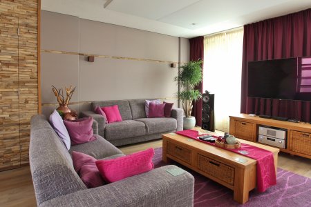 woonkamer met taupe wand en roze accesoires